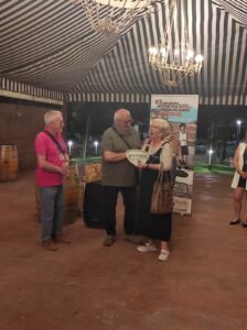 Ángela recibe la placa de manos de Carlos de la Villa, presidente de la Asociación y de Gregorio Cámara director del museo.